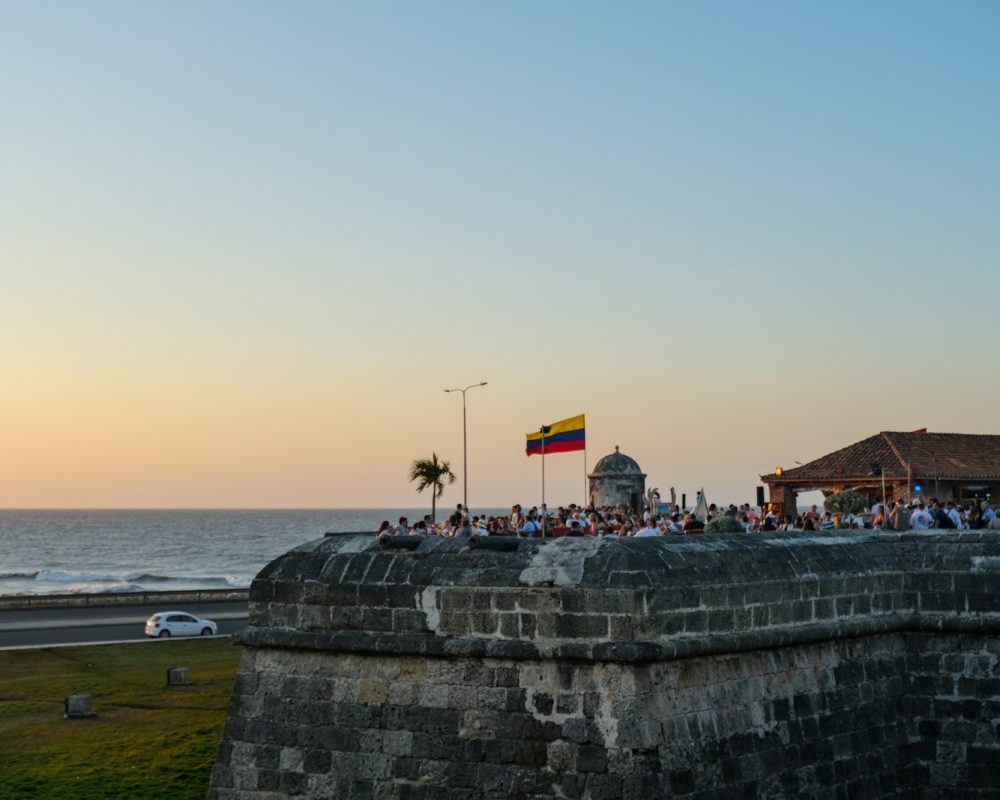 a group of people standing on top of a stone wall